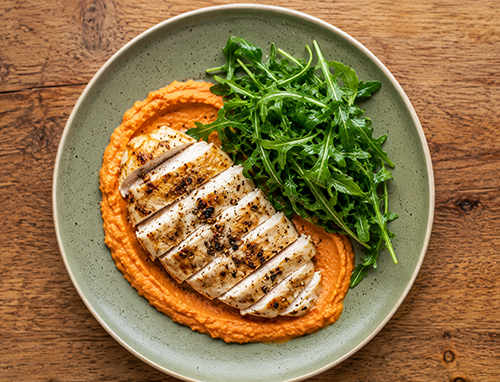 Warm red pepper hummus with coriander chicken breasts